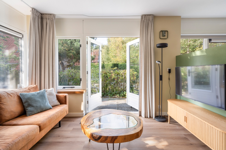 Gezellige woonkamer met openslaande deuren naar terras Boszicht