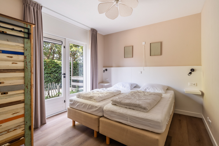Hoofdslaapkamer Boszicht 17 met tweepersoonsbed en tuinzicht.