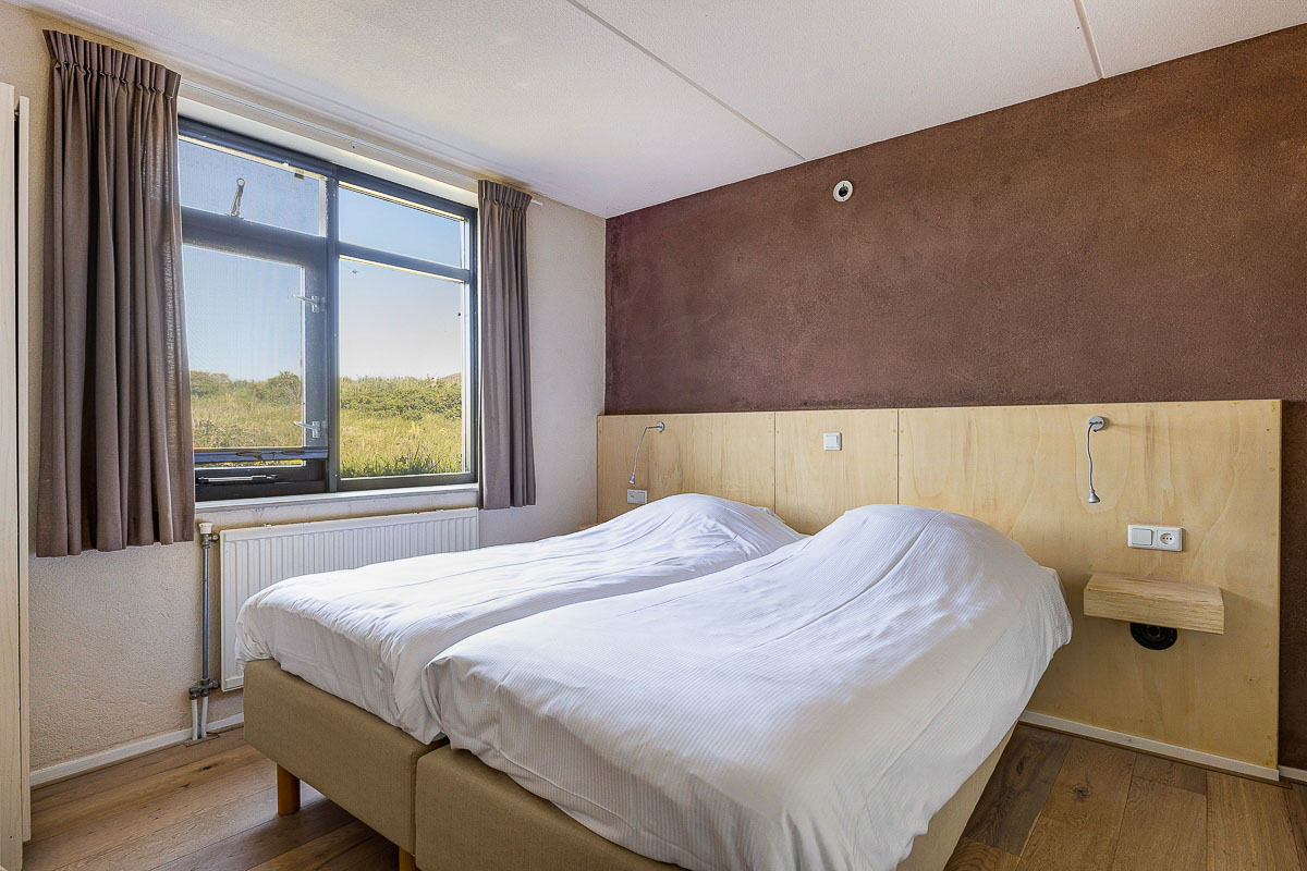 Slaapkamer tweepersoonsbed sepia vakantiehuisje op schiermonnikoog