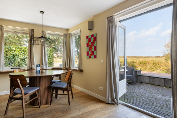Eetgedeelte met openslaande deuren naar terras bij vakantiehuis Boszicht 16a Schiermonnikoog